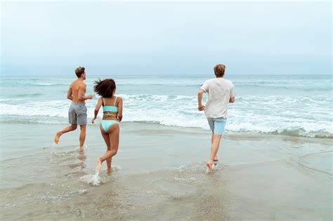 Gente De Tiro Completo Corriendo En La Playa Foto Gratis