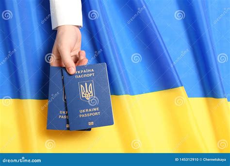 Woman Holding Ukrainian Travel Passports Over National Flag Top View