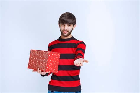 Hombre De Camisa A Rayas Rojas Con Una Caja De Regalo Roja Y