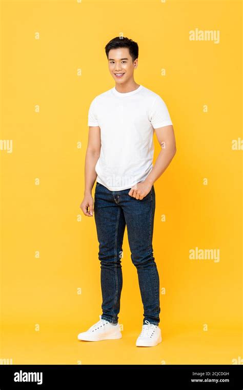 Full length portrait of smiling young handsome Asian man standing with ...