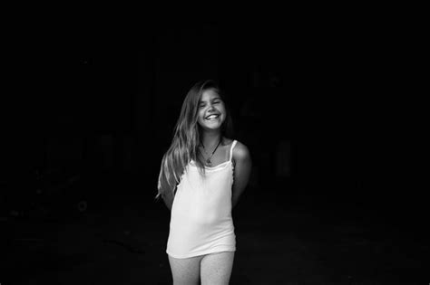 Premium Photo Portrait Of Smiling Girl Standing Against Black Background