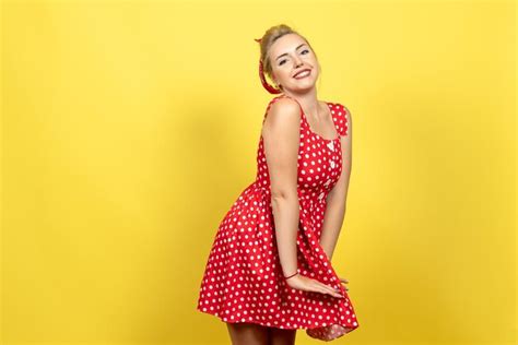 Mujer Joven En Vestido Rojo De Lunares Posando En Amarillo Foto Gratis