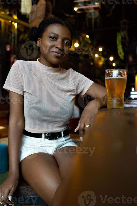 Jeune Femme Noire Avec Une Coiffure Afro Regardant La Caméra Assise Dans Un Bar 4753670 Photo De