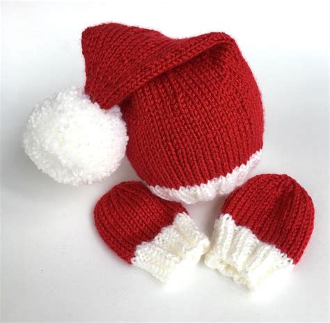 a red and white knitted hat, mittens and booties on a white background