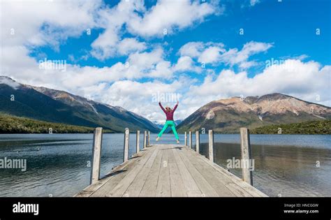 Woman Jumping In The Air Dock On Lake Rotoiti Nelson Lakes National