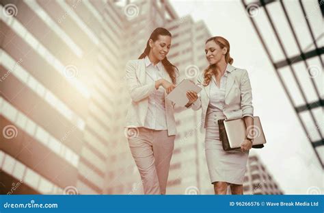 Composite Image Of Businesswomen Using Digital Tablet Stock Photo