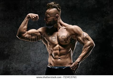 Naked Strong Man Showing His Biceps 库存照片立即编辑723413761