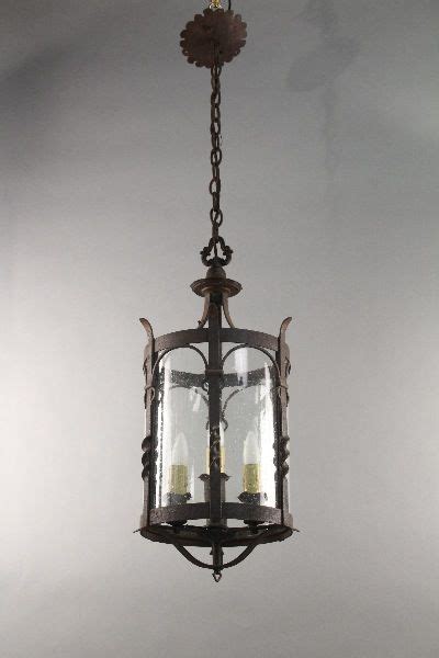 An Old Fashioned Lantern Hanging From The Ceiling With Two Lit Candles