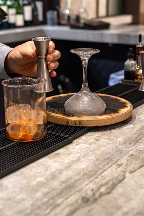 Bartender Holding Jigger And Making Smoked Whiskey Cocktail Drink Stock