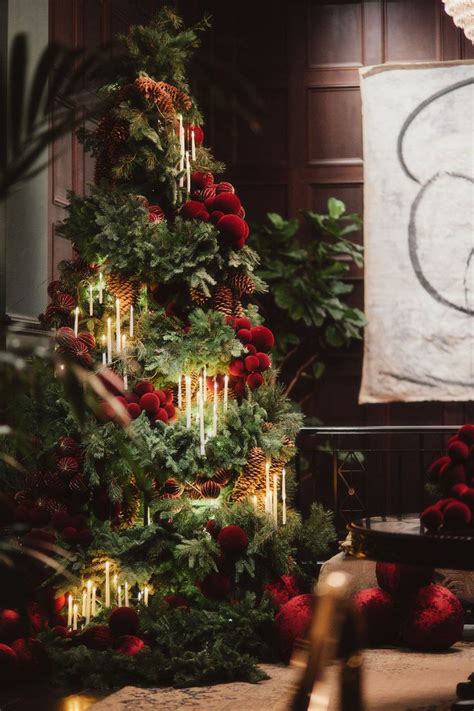 A Decorated Christmas Tree With Red Balls And Greenery