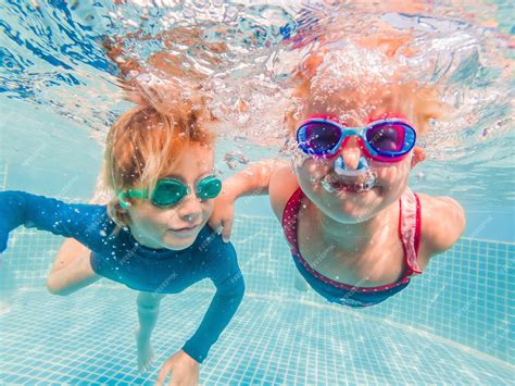 Premium Photo | Kids having fun playing underwater in swimming pool on ...