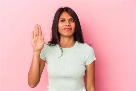 Jovem mulher latina isolada no fundo rosa sorrindo alegre mostrando o número cinco os dedos