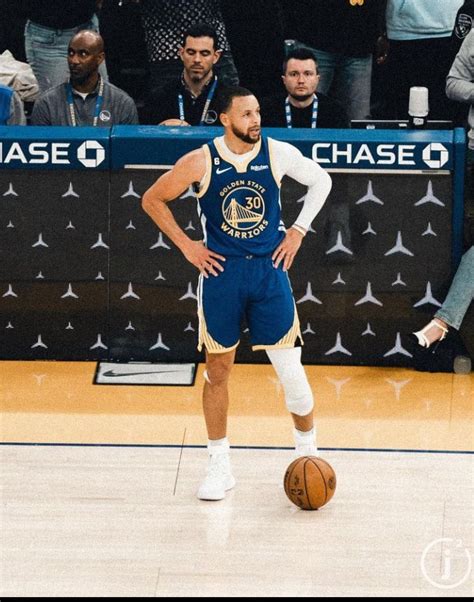 A Man Standing On Top Of A Basketball Court Next To A Ball In Front Of Him