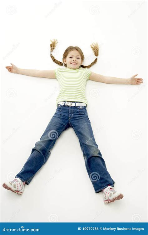 Studio Portrait Of Smiling Girl Lying Down With Ar Stock Photo Image