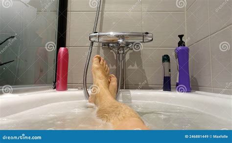 Feet Sticking Out Of The Water And Soap Suds During A Hot Bath Stock