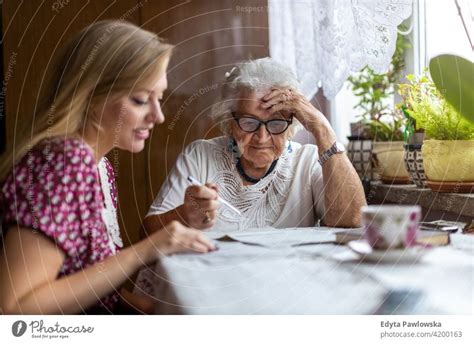 Young Woman Spending Time With Her Elderly Grandmother At Home A