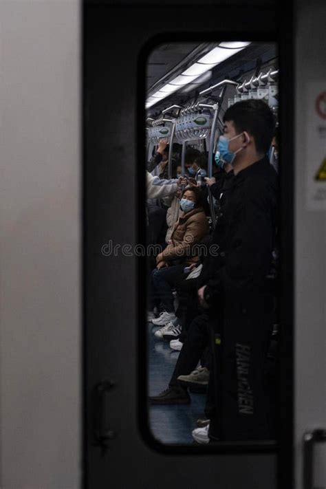 Vertical Shot Of People Wearing Face Masks On A Crowded Public Subway