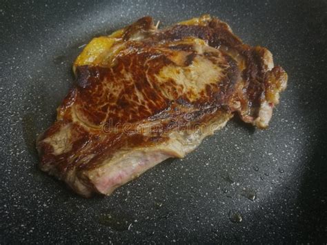 Toma De Carne De Ternera Cocida En Una Sartén Frita Negra Imagen de