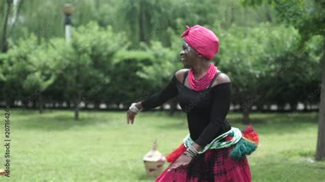 African women are dancing a folk traditional dance on a grass meadow ...