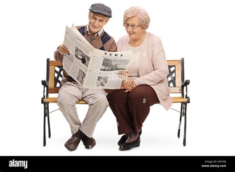 Les personnes âgées assises sur un banc et lire un journal ensemble