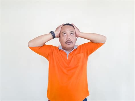 Hombre adulto asiático con camiseta naranja haciendo gestos y