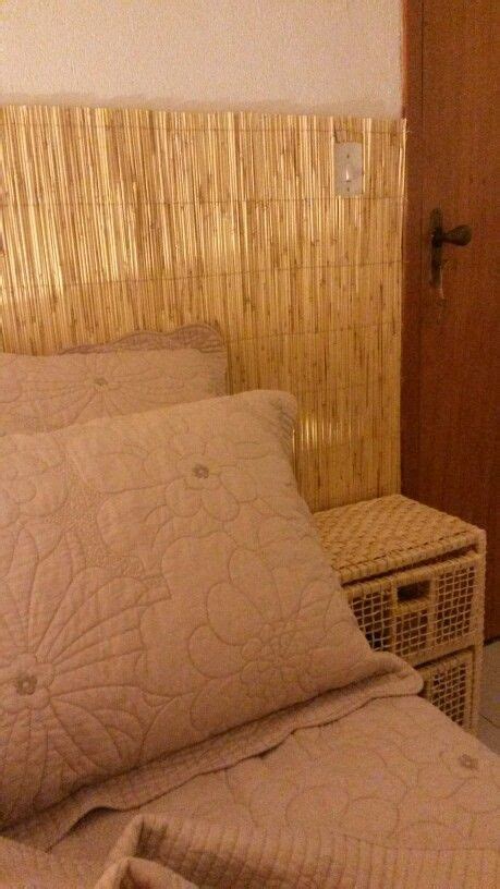 A Bed With Two Pillows On Top Of It Next To A Wicker Basket And Door