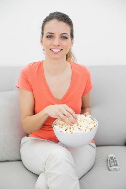 Premium Photo Attractive Smiling Woman Eating Popcorn While Watching