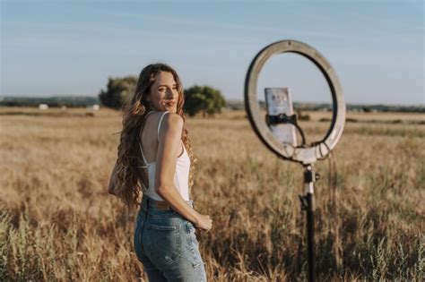 Free Photo Pretty Spanish Blonde Taking A Selfie In A Field With Her Phone Mounted On A Ring Light