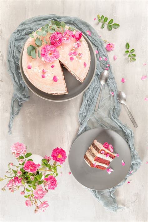 Red Velvet Naked Cake With Fresh Roses And Swiss Buttercream On Kitchen Countertop Stock Photo