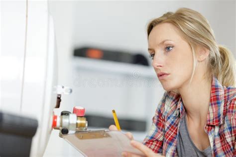 Female Plumber With Clipboard Looking At Boiler Stock Photo Image Of