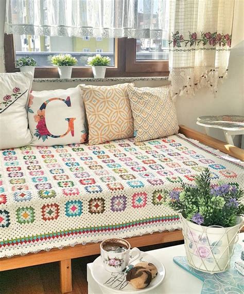 A Living Room With A Couch Covered In Pillows And Quilts On The Table