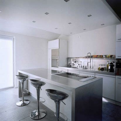 A Kitchen With Two Bar Stools Next To An Island