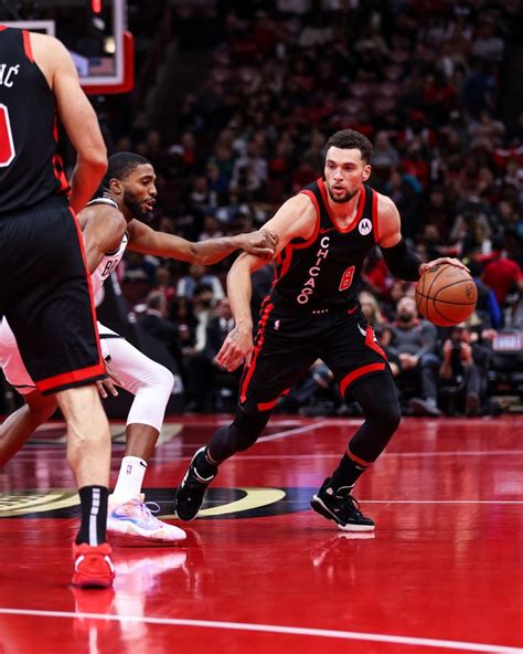 Two Basketball Players Are On The Court With One Player Dribbling At