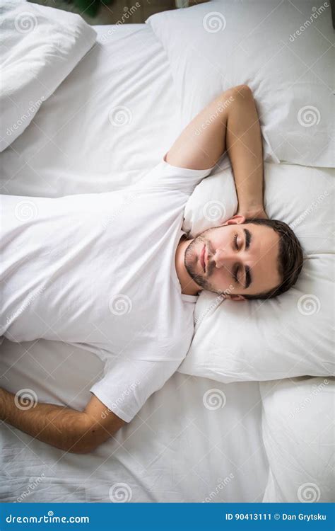 Portrait Of A Young Man From Above Sleeping In A White Bed At Home