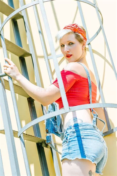 Jeune Fille De Pin Up Blonde Avec Un Arc Rouge Sur Un Escalier De Secours Femme De Pin Up Du