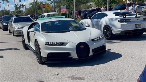 some very nice looking cars parked in a parking lot with people ...