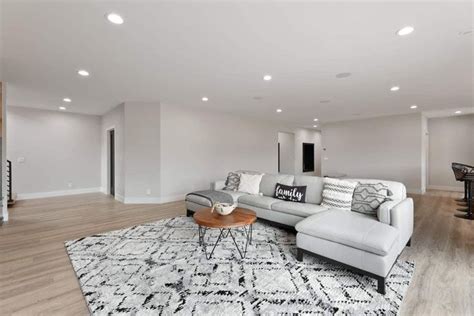 A Large Living Room With Hardwood Floors And White Walls Along With An