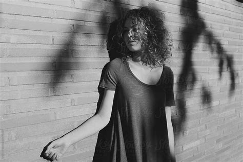 Young Woman Standing In Shadow Falling On Brick Wall By Stocksy Contributor Tana Teel Stocksy