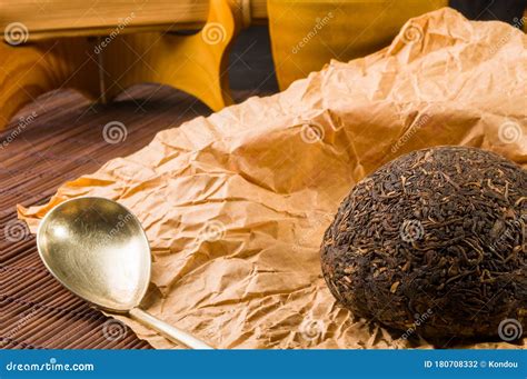 Chinese Pressed PU Erh Tea On Wrapping Paper And Tea Accessories On A