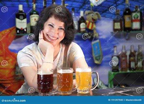 The Girl Is A Bartender And Three Beers Glasses With Different Sorts