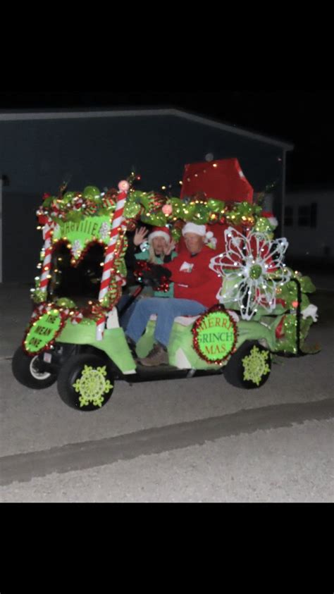 A Man Riding On The Back Of A Green Truck Decorated With Christmas