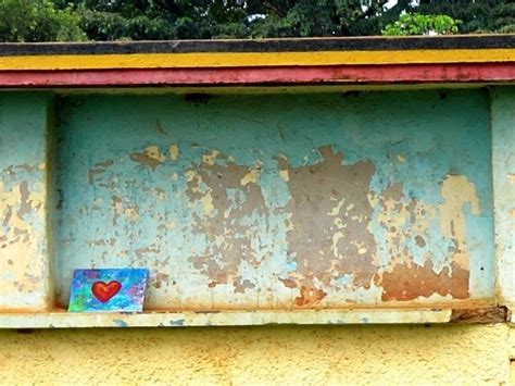 An Old Blue And Yellow Building With A Red Heart On The Window Sill In