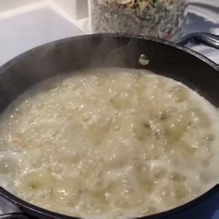 A Pan Filled With Food Sitting On Top Of A Stove Next To A Pot Of Broth