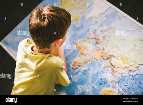 Niño estudiando el mapa del mundo Soñando con viajar en tiempos de