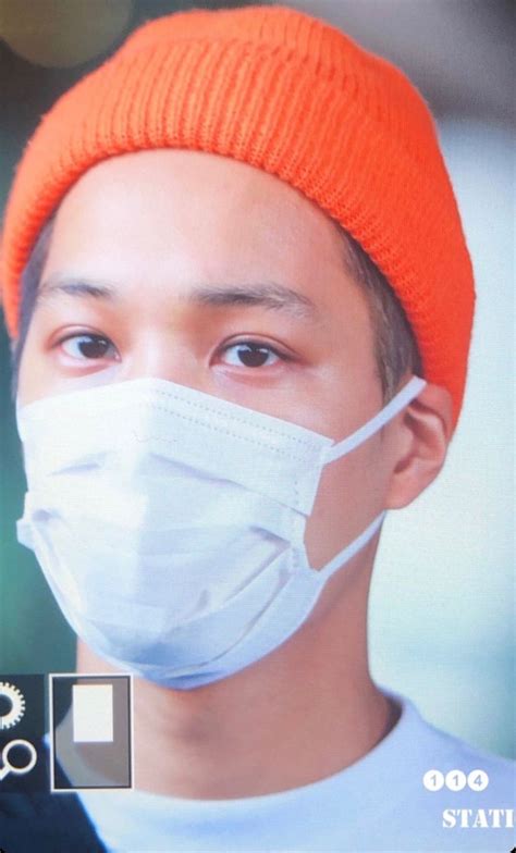 A Man Wearing An Orange Beanie And A Face Mask