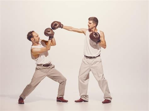 Premium Photo | Portrait of two men playing boxing in gloves isolated over grey studio ...