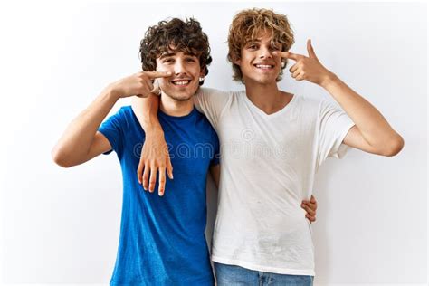 Jeune Couple Gay Debout Sur Un Fond Isolé Pointant Du Doigt à Main Et