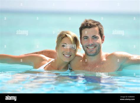 Couple swimming in infinity pool Stock Photo - Alamy