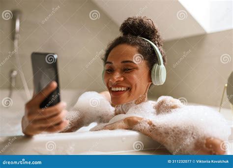 Woman Smiles In Bathtub Wearing Headphones Comfortable And Happy Stock Image Image Of