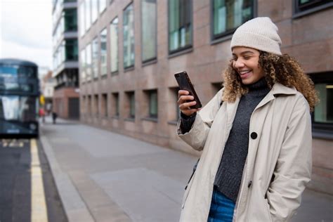 Jeune Femme à Laide De Son Smartphone Dans La Ville Photo Gratuite